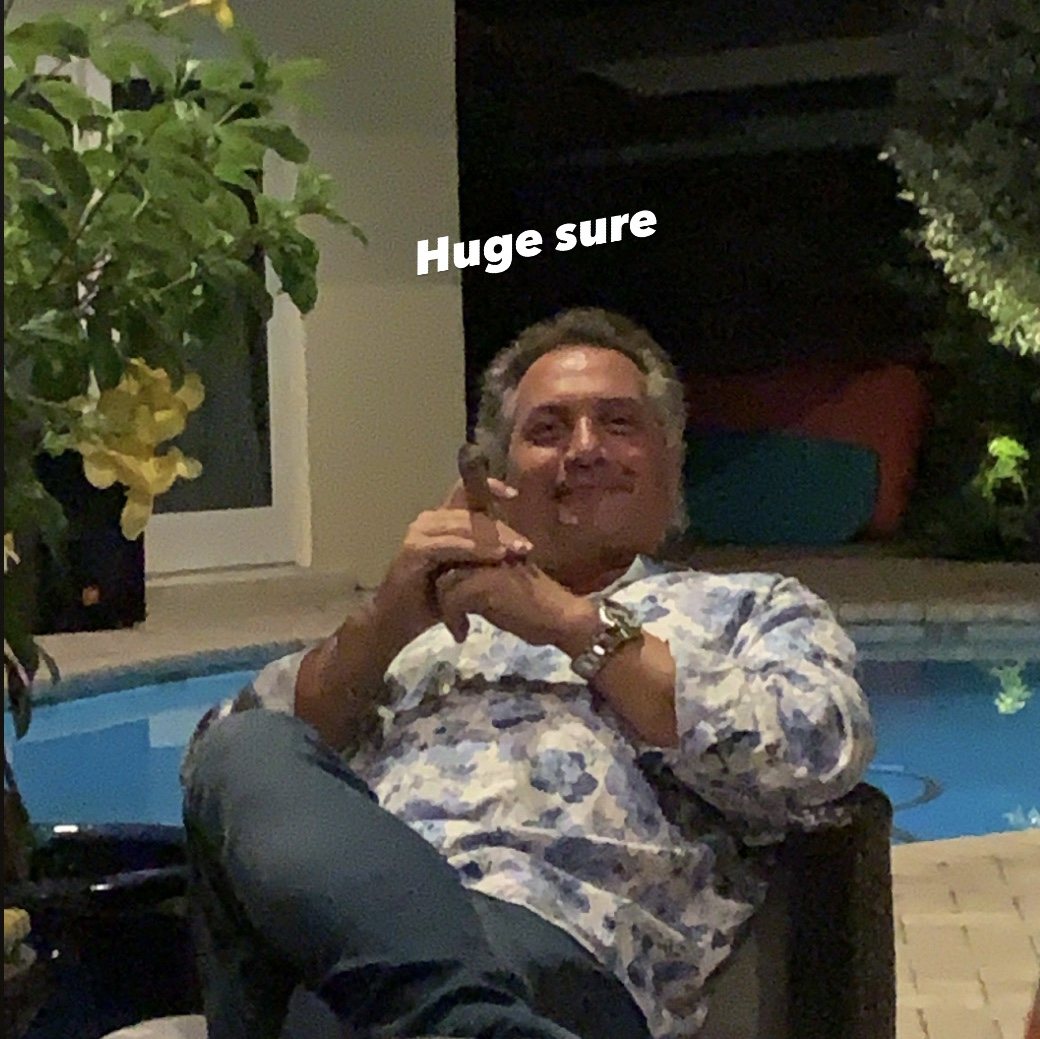 Dad leaning back in a pool chair, hands folded, giving a knowing look